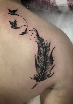 Tatouage plume derrière l'épaule avec trois petits oiseaux